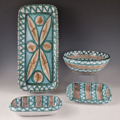 Trois pièces de poterie décorative sont exposées sur une table