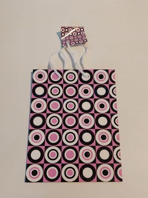 a pink and black bag with black and white circles on it