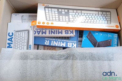 a box with a keyboard, mouse, and other electronic items in it