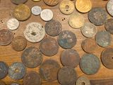 a lot of old coins on a table with a pair of scissors