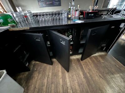 un comptoir sur lequel sont posées de nombreuses bouteilles et verres