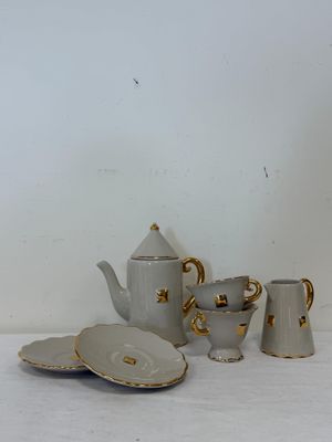 une table blanche sur laquelle se trouvent une théière et une assiette
