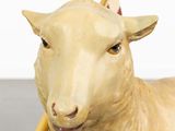 a statue of a sheep with a baseball bat in it ' s mouth