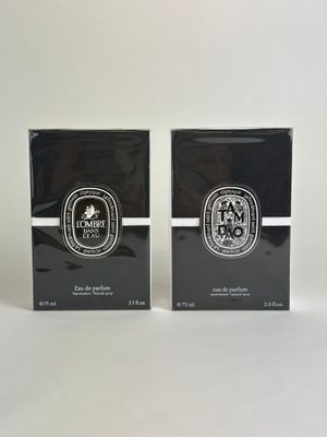 two boxes of perfume sitting on top of a white surface