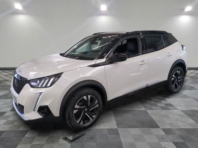 un SUV Nissan blanc garé sur un sol à damier dans un garage