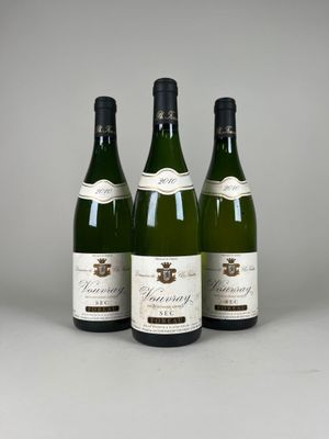 trois bouteilles de vin sont alignées sur une table