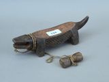 une vieille figurine en bois représentant un chien, avec une corde autour du cou