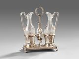 two glass vases on a stand with a key in the middle
