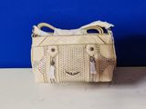 un sac à main blanc posé sur une table près d'un mur bleu