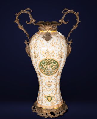 un vase richement décoré posé sur un socle, sur fond bleu foncé