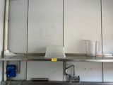 a kitchen with a stainless steel sink and a metal shelf