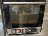 a small oven sitting on a stand in a kitchen