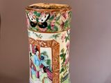 a vase with a painting on it sitting on a table