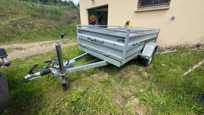 une remorque garée dans l'herbe près d'un bâtiment