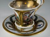 an antique cup and saucer on a saucer with a gold rim
