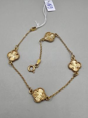an image of a gold bracelet with flowers on it