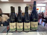 six bottles of wine sitting on top of a table in a store