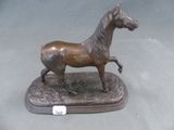 statue en bronze représentant un cheval, posée sur un socle et accompagnée d'une étiquette indiquant le prix
