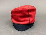 a red and black hat on a gray surface