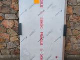 a white door with a sticker on it in front of a stone wall