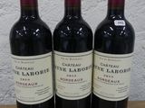 trois bouteilles de vin posées sur une table en bois