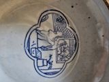 a blue and white bowl with a picture of a man on it