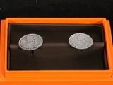 pair of silver cufflinks in an orange box on a black surface