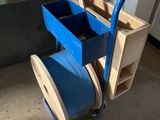 un diable bleu sur lequel est posée une caisse en bois