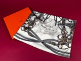 a close up of a scarf on a red surface with an orange box