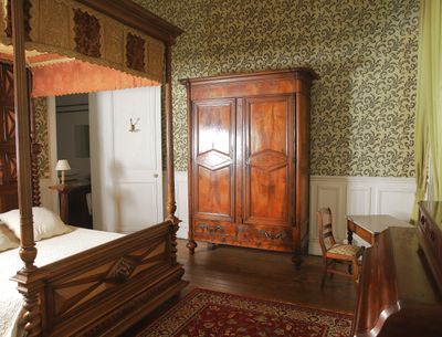 a bedroom with a four poster bed and a dresser in it