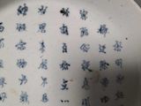 a white plate with blue writing on it on a table
