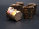 four small cups are lined up in a row on a table