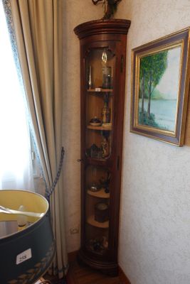 une armoire d'angle placée dans un coin de la pièce, près d'une fenêtre