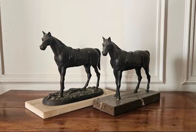 deux statues de chevaux posées sur une table en bois