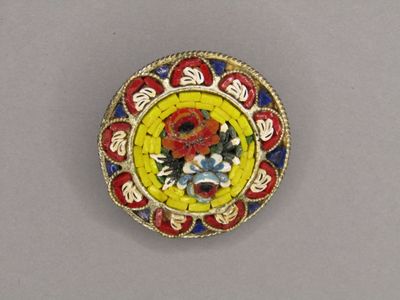 an image of a yellow and red broochle with flowers on it