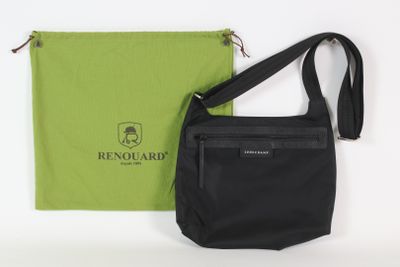 le sac noir se trouve à côté d'un sac vert, posé sur une surface blanche