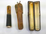 an old wooden case with a pen and a lighter in it