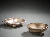 paire de plats en argent posés sur un socle, sur un fond gris