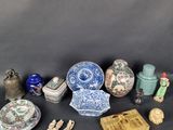 Divers vases et figurines chinois sont exposés sur un fond noir.