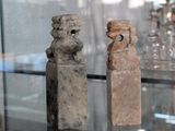 deux figurines en pierre exposées dans une vitrine