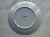 a white plate with red writing on it sitting on a table