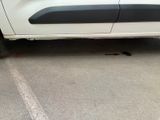 a white car parked in a parking lot with a black stripe