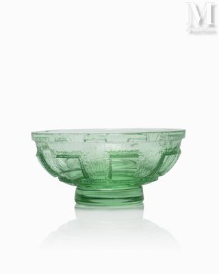 a green glass bowl sitting on top of a white table