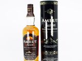 une bouteille de whisky irlandais Amrut à côté d'un bidon