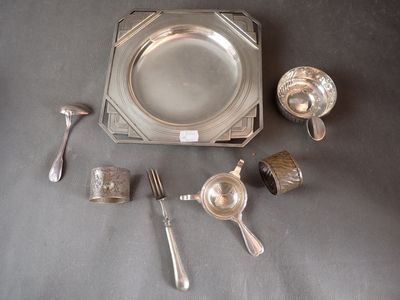 a silver plate with spoons, cups, and spoons on a table