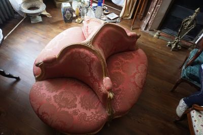 une chaise rose qui se trouve dans un salon