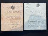 two old papers are sitting on top of a black table