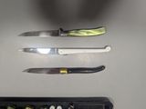 three knives that are sitting on top of a table