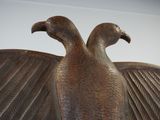 a bronze sculpture of a bird that is sitting on top of a table