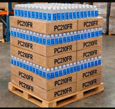 Des cartons d'eau sont empilés sur une palette dans un entrepôt
